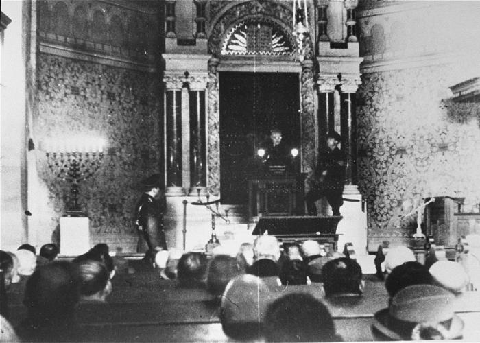 Члены еврейской общины Баден-Баден вынуждены сидеть в синагоге и слушайте, а отрывки из  Майн Кампф Гитлера вслух из бимы (lecturn)