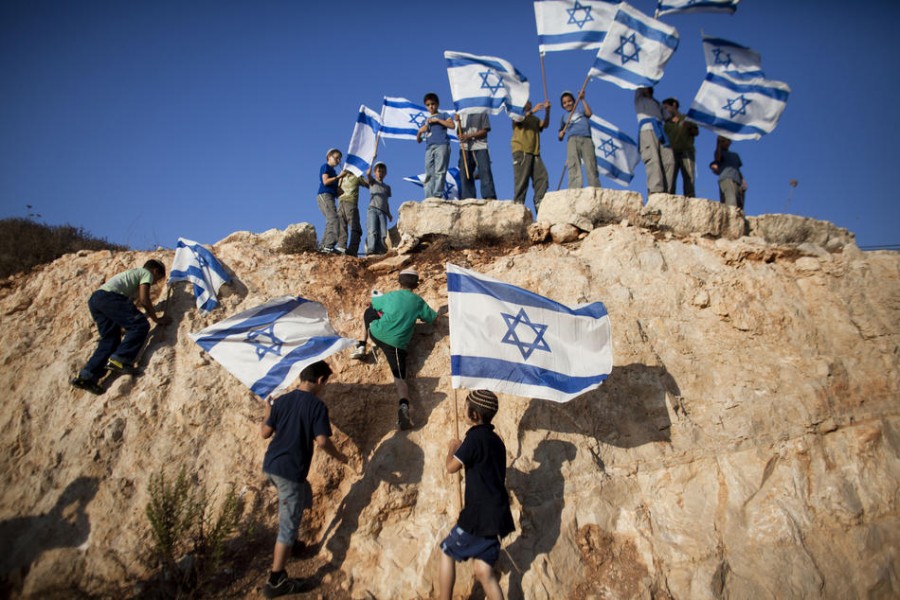 Израильские дети размахивают флагами во время акции протеста, организованной еврейскими поселенцами Итамара против государственности Палестины