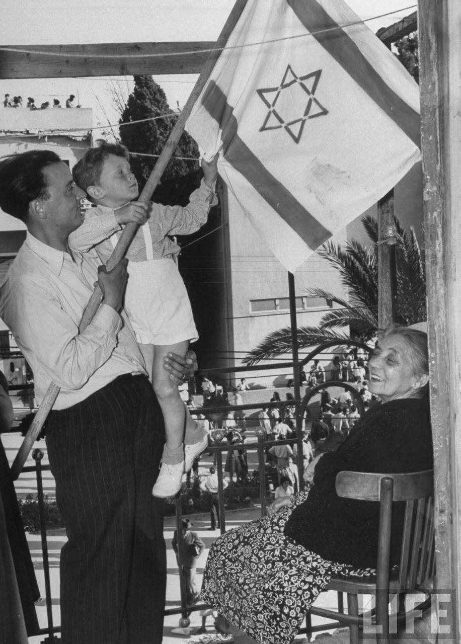 1948. Май. Счастливая еврейская семья рассматривает флаг Израиля после окончания британского мандата